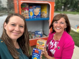 employees standing in front of blessing box with food items